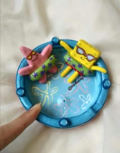 two toy figures are sitting on top of a blue plate