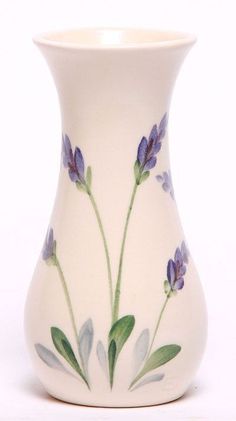 a white vase with purple flowers painted on it