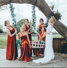 a group of women standing next to each other under a tree