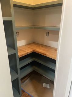 an empty room with shelves in the corner and wood flooring on the other side