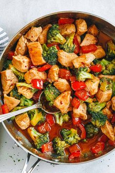 chicken and broccoli stir fry in a skillet with tongs on the side