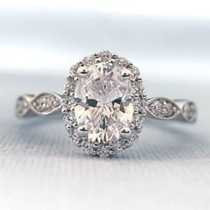 an oval shaped diamond ring with diamonds around it