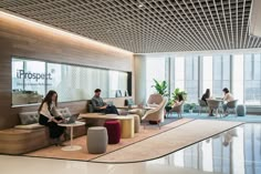 people sitting at tables in an office lobby