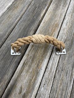 a close up of a rope on a wooden floor with two metal clips attached to it