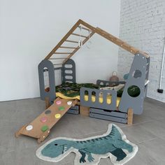 a child's bedroom with a dinosaur bed and play set in the corner, next to a ladder