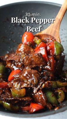 a close up of food in a pan on a table with a wooden spoon and the words 30 min black pepper beef