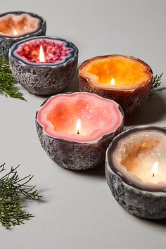 four candles with different colors in them on a table