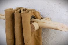 a curtain is hanging on the side of a white wall with a wooden rod attached to it