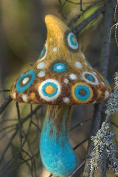 a blue and brown mushroom sitting on top of a tree branch