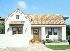 a white house with a brown door and tiled roof