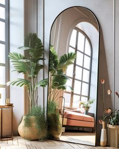 a large mirror sitting on top of a wooden floor next to a potted plant