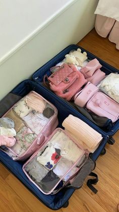 two suitcases filled with clothes sitting on the floor