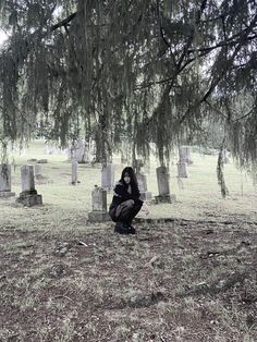 a woman kneeling down in front of a tree