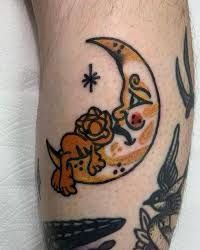 a man with a tattoo on his leg that has a dog sitting on the moon