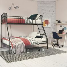 a black bunk bed sitting in a bedroom next to a white brick wall and desk