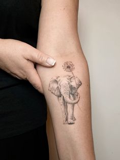 an elephant tattoo on the left arm