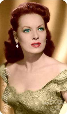 an old photo of a woman with blue eyes wearing a green dress and red lipstick