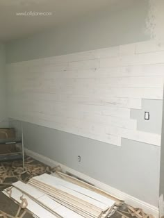 a room that is being remodeled with wood planks on the floor and white paint