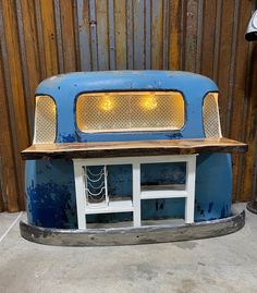 an old blue truck with yellow lights on it's hood and front grills