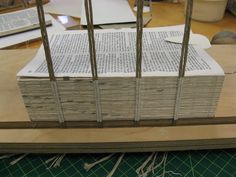 several stacks of books sitting on top of a table next to a pair of scissors