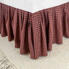 a bed with a red and white checkered bedspread on top of it