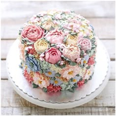 a close up of a cake on a plate with flowers in the middle and frosting