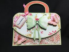 a handbag made out of paper with a bow on the front and butterflies on the back