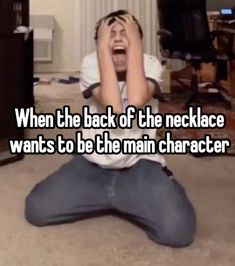 a man sitting on the floor with his head in his hands and texting when the back of the necklace wants to be the main character