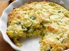 a casserole with zucchini and spinach on top in a white dish