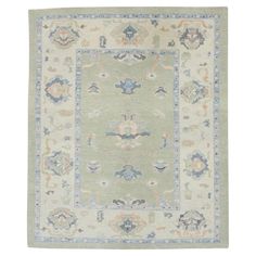 a green rug with blue and white designs on the bottom, in front of a white background