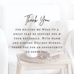 a table with a book and cup on it in front of a white couch that says, thank you for helping me wrap up a great year of serving you & your refer