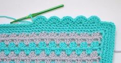 two crocheted dishcloths on a table with a green knitting needle next to them