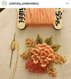 two spools of thread are sitting on a table next to an orange flower