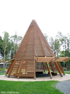 a large wooden structure sitting on top of a lush green field