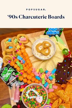 a wooden table topped with lots of candy and candies next to snacks on top of it