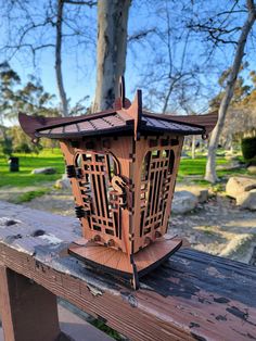 a wooden lantern sitting on top of a wooden bench