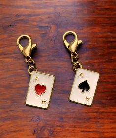 two pairs of gold toned playing cards with red heart and spades on them