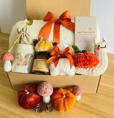 a box filled with lots of different items on top of a wooden table next to a stuffed animal