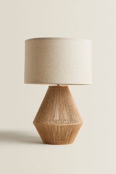 a table lamp with a beige shade on it's base and a white linen lampshade