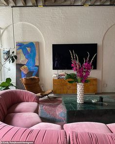 a living room filled with furniture and a large flat screen tv mounted to the wall