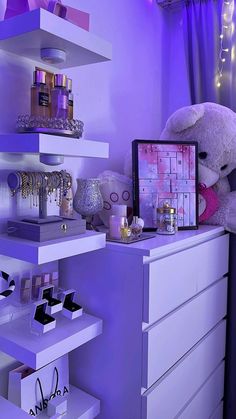 a teddy bear sitting on top of a dresser in a room with purple walls and furniture