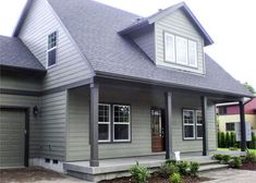 a gray house with two garages and three windows