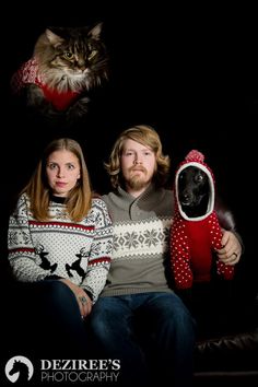 a man and woman sitting next to a cat