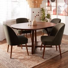 a dining room table with four chairs and a rug on the floor in front of it