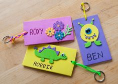 three different colored cards on a table with keychains attached to them that say roly, robbie, and ben