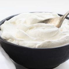 a black bowl filled with whipped cream and a spoon