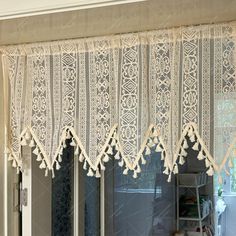 an open window with white lace on it