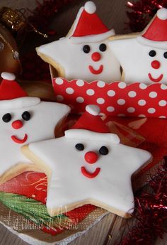 decorated cookies with white frosting and red decorations