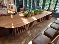 a large wooden table surrounded by brown leather chairs