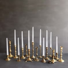 a bunch of candles that are sitting in the middle of a row on a table